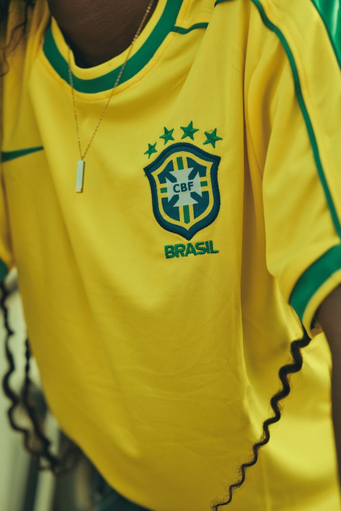 Yellow Brazil soccer jersey with emblem and necklace detail.